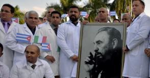 Médicos y enfermeras de la Brigada Médica Internacional Henry Reeve de Cuba posan con un retrato del líder cubano Fidel Castro mientras se despiden antes de viajar a Italia para ayudar en la lucha contra la pandemia del coronavirus COVID-19, en la Unidad Central de Cooperación médica en La Habana, el 21 de marzo de 2020. Foto: Yamil LAGE / AFP Médicos y enfermeras de la Brigada Médica Internacional Henry Reeve de Cuba posan con un retrato del líder cubano Fidel Castro mientras se despiden antes de viajar a Italia para ayudar en la lucha contra la pandemia del coronavirus COVID-19, en la Unidad Central de Cooperación médica en La Habana, el 21 de marzo de 2020. Foto: Yamil LAGE / AFP